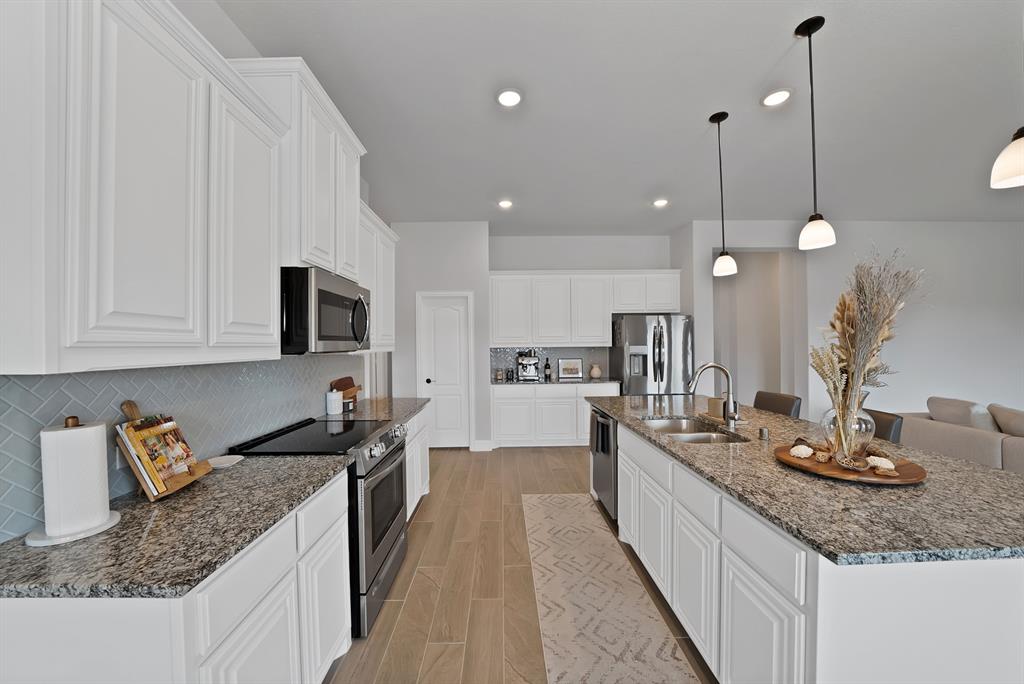 4054 Grove Valley Road Midlothian, TX 76065 - Photo 12 of 25 a kitchen with kitchen island granite countertop a sink a counter space appliances and cabinets