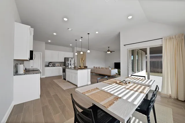 a kitchen with stainless steel appliances granite countertop a stove a refrigerator a kitchen island a sink and a refrigerator