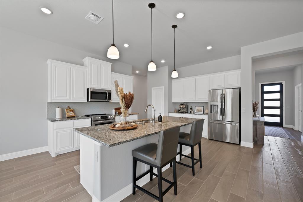 4054 Grove Valley Road Midlothian, TX 76065 - Photo 15 of 25 a kitchen with stainless steel appliances granite countertop a stove a refrigerator a kitchen island a sink and a refrigerator