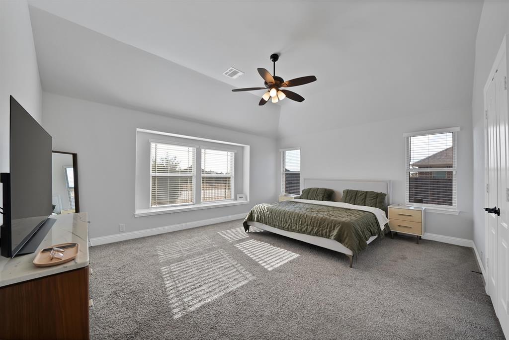 4054 Grove Valley Road Midlothian, TX 76065 - Photo 16 of 25 a spacious bedroom with a bed a window and dresser