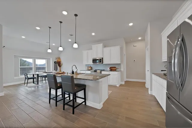 a large kitchen with a table and chairs