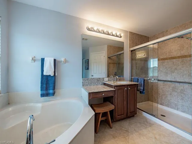a bathroom with a bathtub a sink and a large mirror
