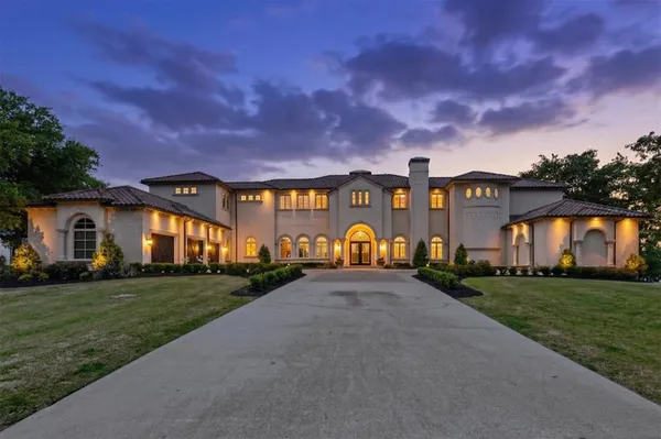 a view of a big house with a big yard and large trees