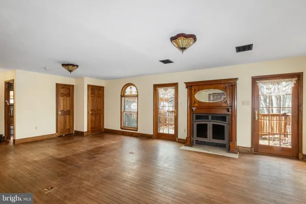 a view of an empty room with window and fireplace