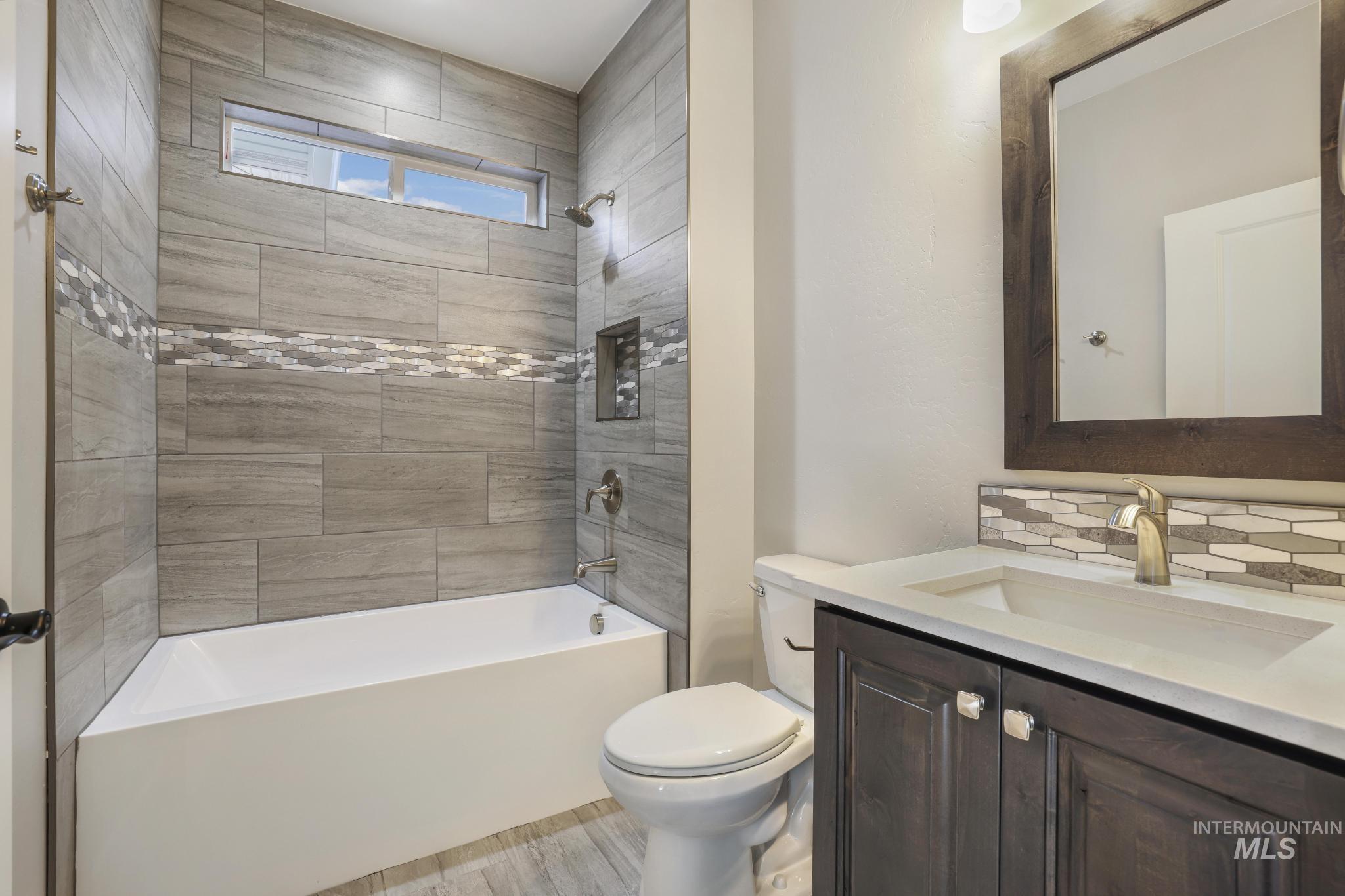 298 Sandi Road Twin Falls, ID 83301 - Photo 24 of 24 Bathroom featuring a tub/shower combination with gray subway tile surround and a decorative mosaic accent strip