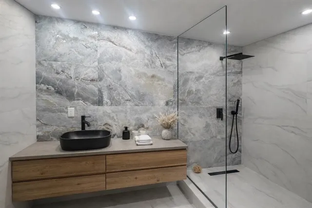 a bathroom with a sink a mirror and shower