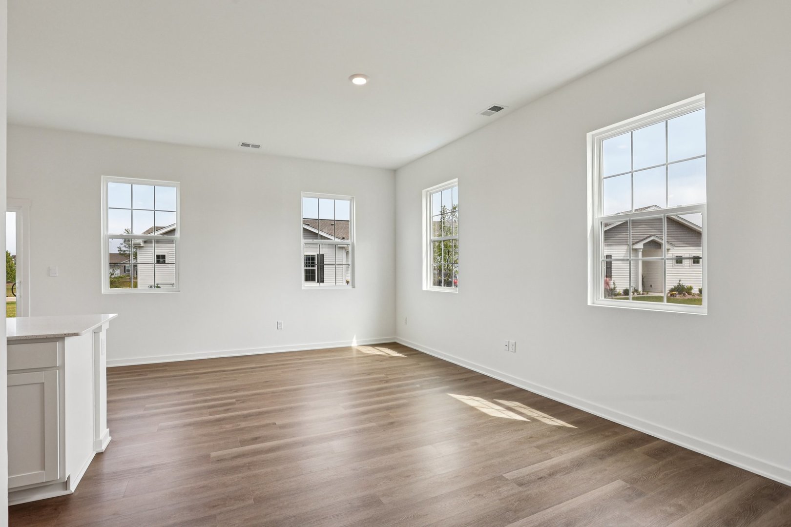 6481 Juniper Drive Wonder Lake, IL 60097 - Photo 4 of 59 an empty room with wooden floor and windows