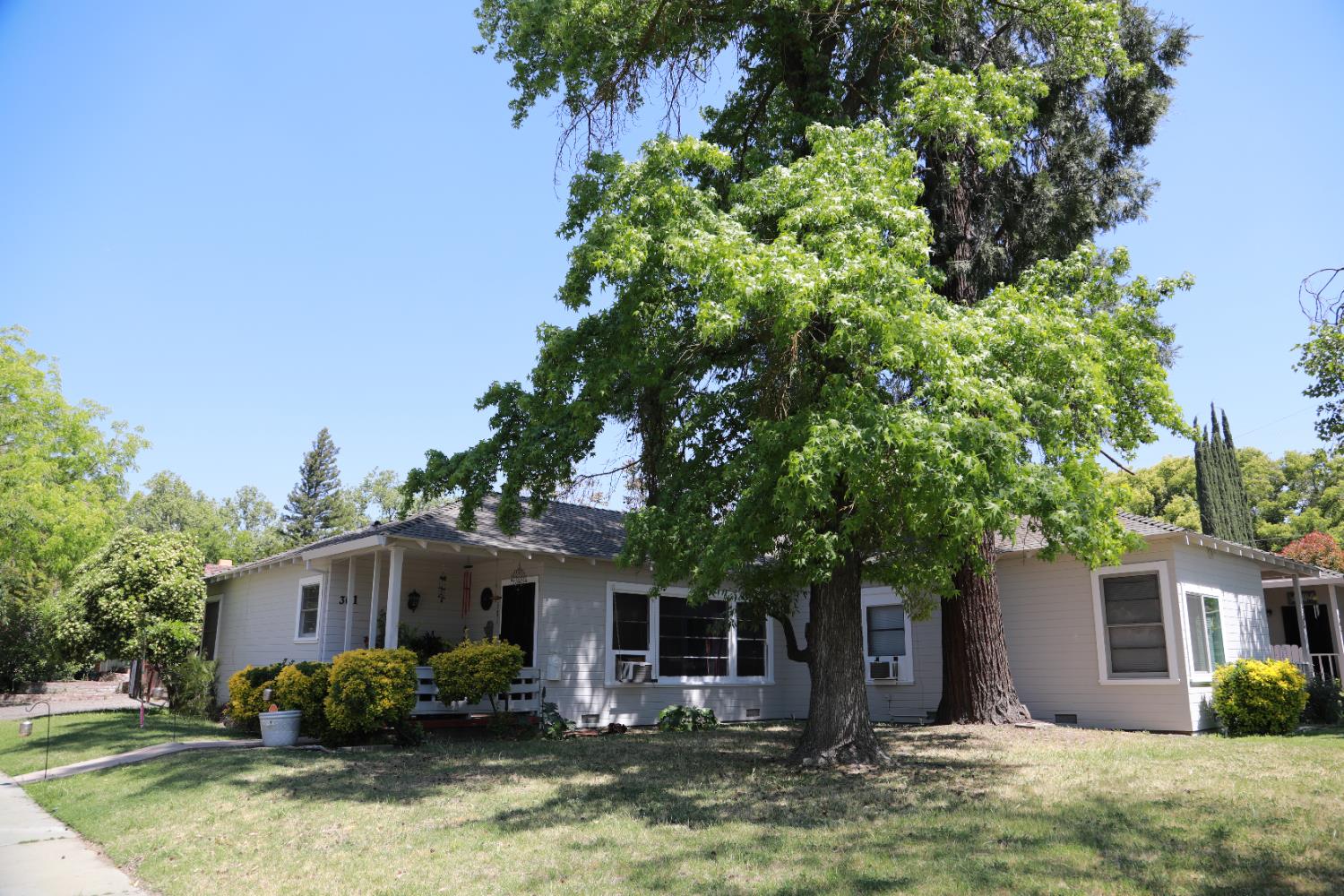 a front view of house with yard and trees around