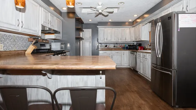 a kitchen with kitchen island a counter space a sink appliances and cabinets
