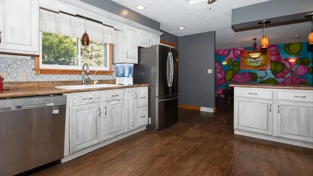a kitchen with stainless steel appliances granite countertop a refrigerator and a sink