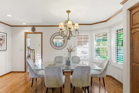 a view of a dining room with furniture a chandelier and wooden floor