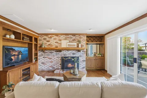 a living room with furniture a flat screen tv and a fireplace