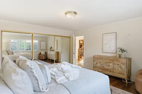 a bedroom with a bed and large windows