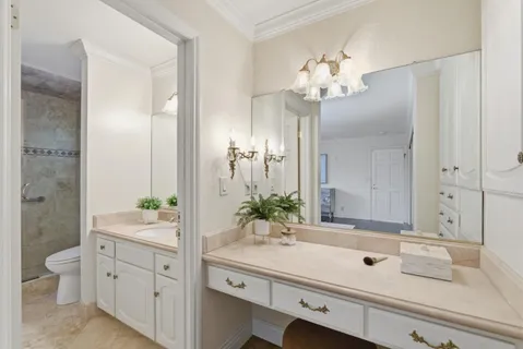 a bathroom with a sink a toilet and a large mirror
