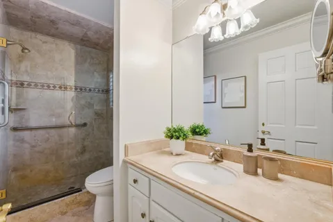 a bathroom with a granite countertop sink a toilet and a mirror
