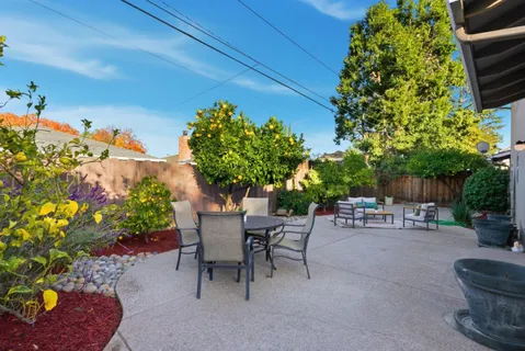 a view of a patio with table and chairs and potted plants