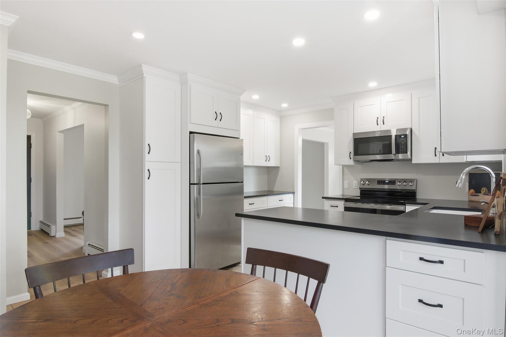 14 Flax Pond Woods Road Setauket, NY 11733 - Photo 17 of 41 a kitchen with stainless steel appliances granite countertop a refrigerator a sink a stove a microwave a counter top and cabinets