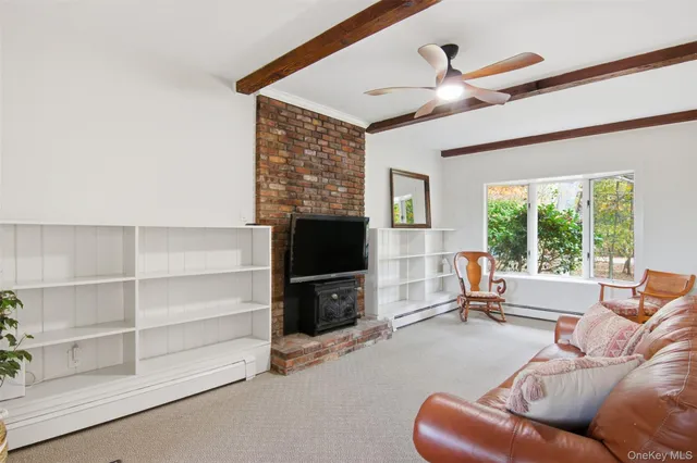 a living room with furniture a flat screen tv and a large window