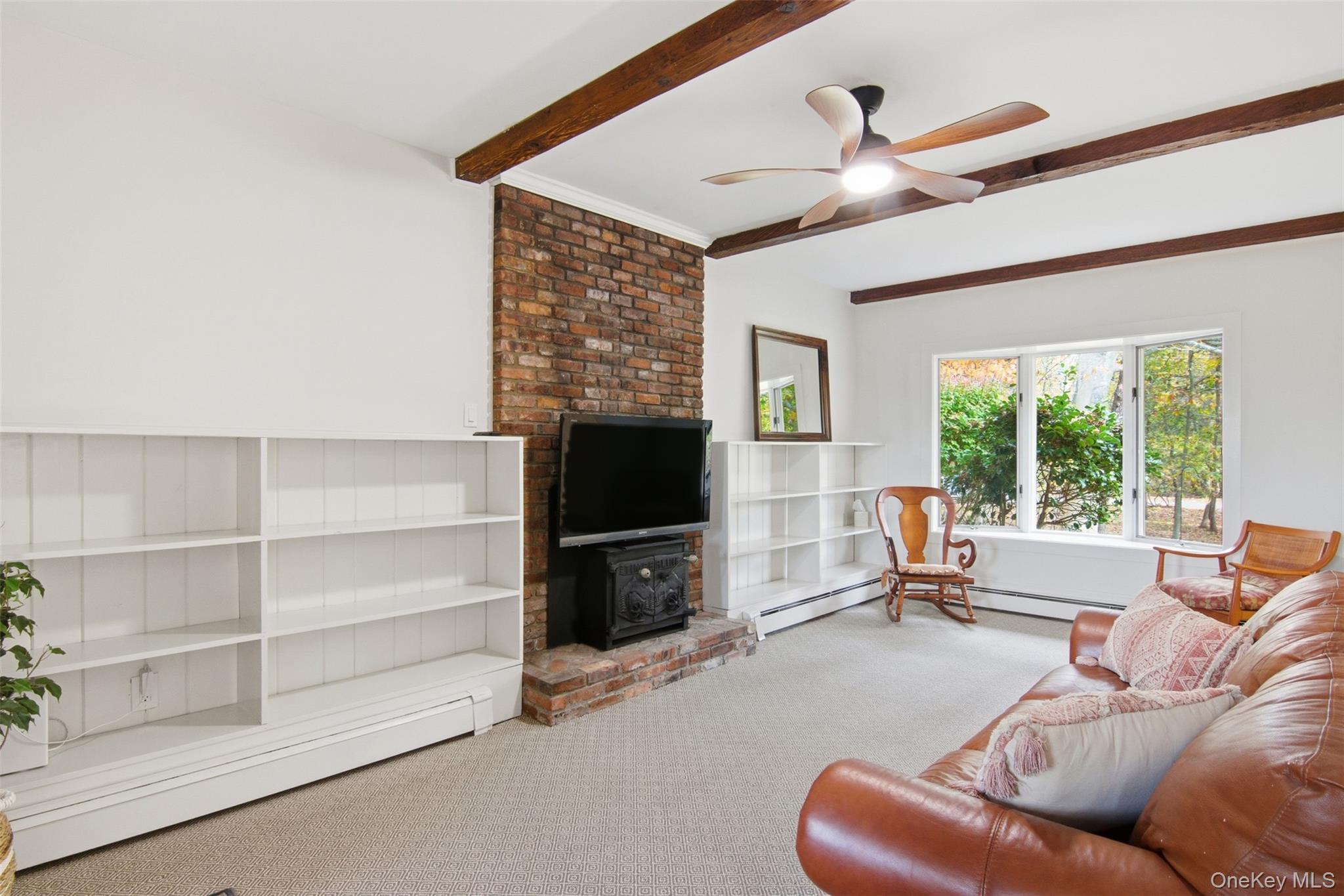 14 Flax Pond Woods Road Setauket, NY 11733 - Photo 21 of 41 a living room with furniture a flat screen tv and a large window