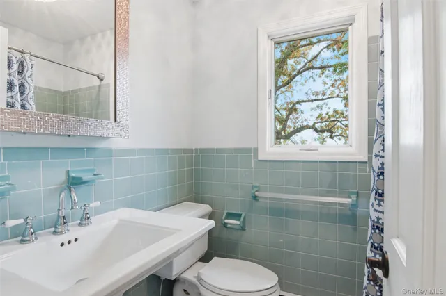a bathroom with a sink a toilet and a mirror