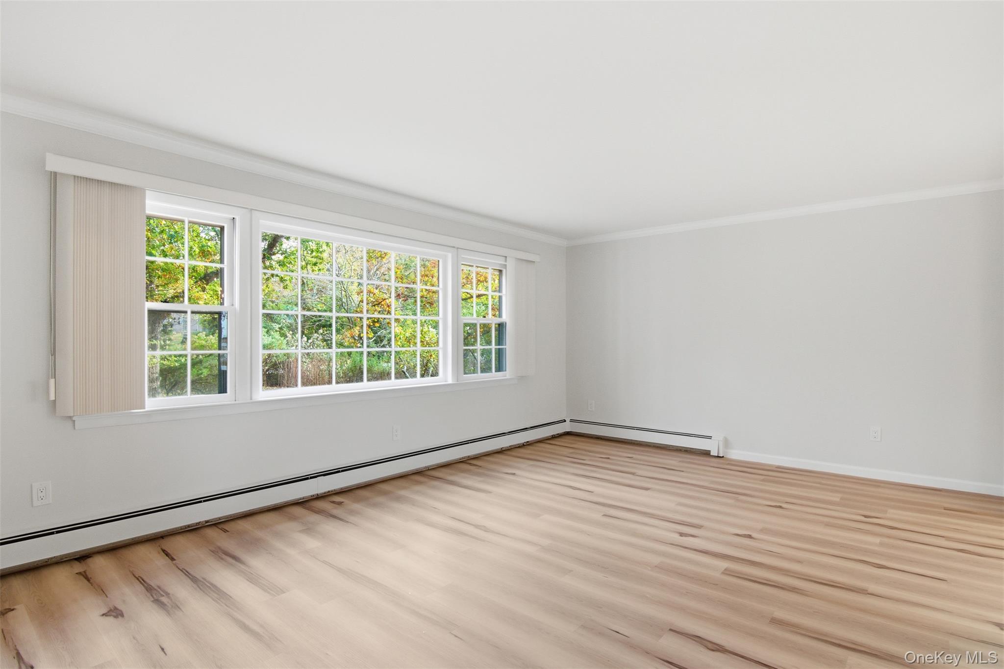 14 Flax Pond Woods Road Setauket, NY 11733 - Photo 6 of 41 a view of an empty room with wooden floor and a window