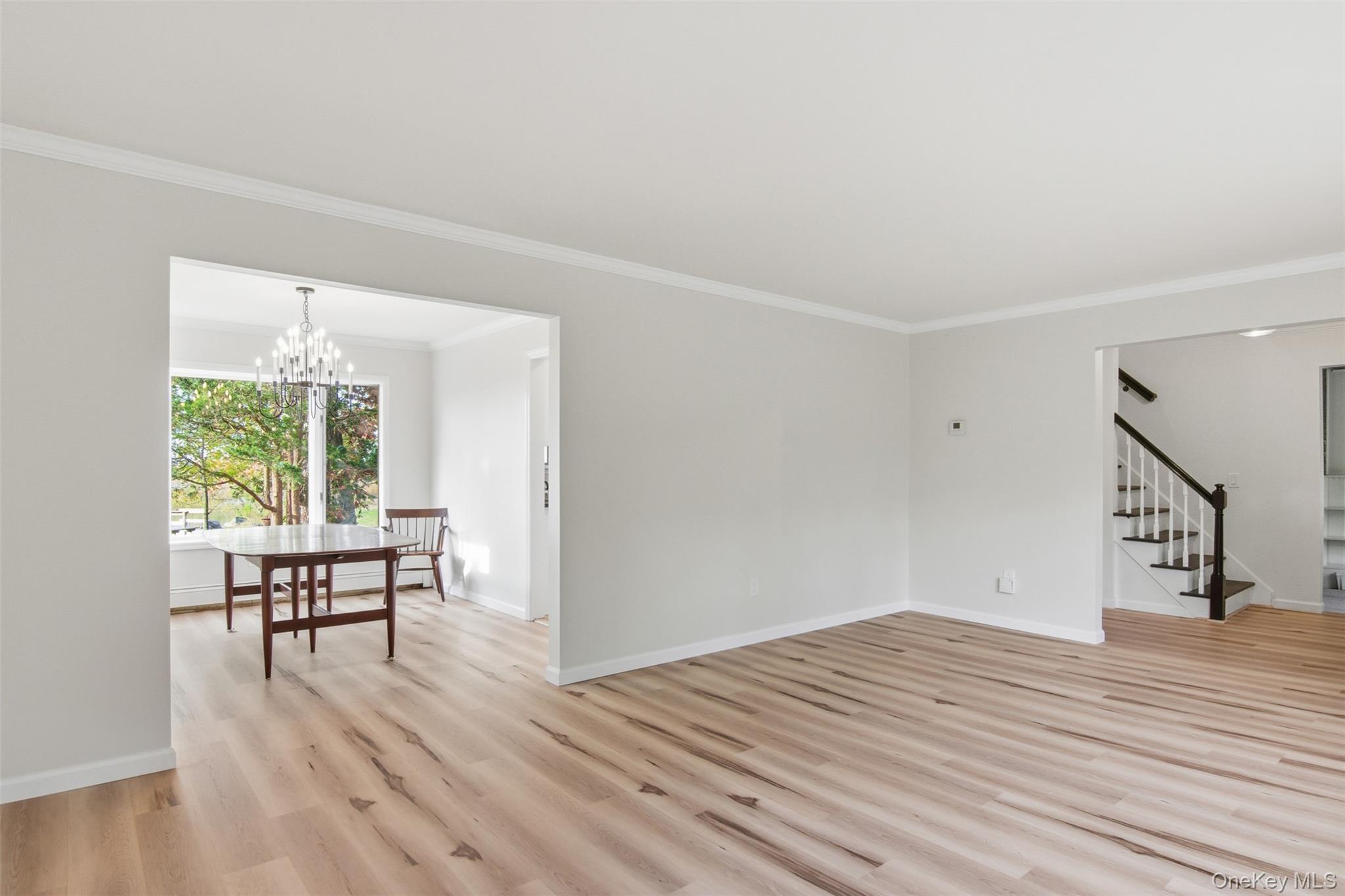 14 Flax Pond Woods Road Setauket, NY 11733 - Photo 8 of 41 a view of a livingroom with wooden floor and a floor to ceiling window