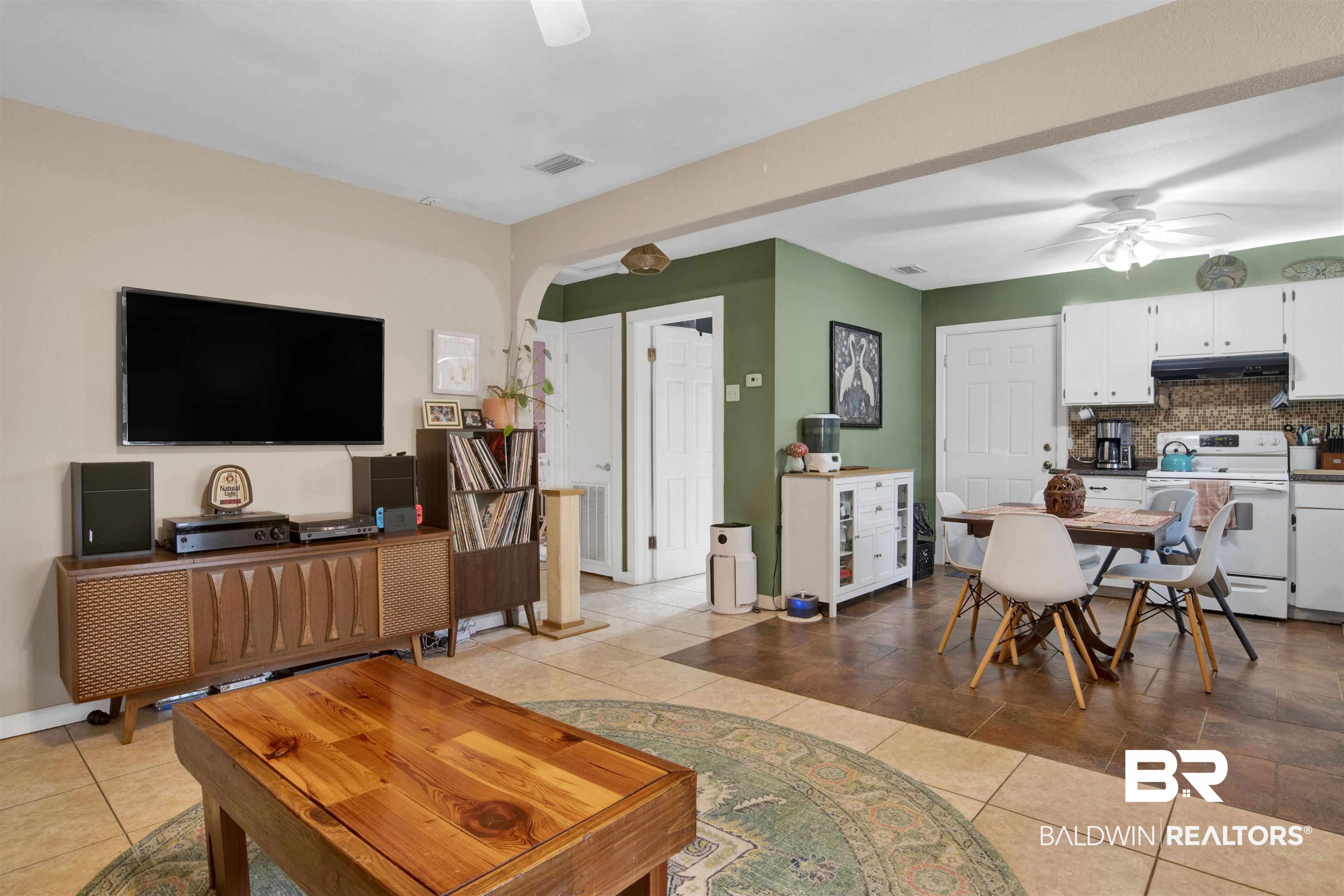 1100 North Pine Street Foley, AL 36535 - Photo 4 of 30 Open concept living space featuring neutral-toned walls, tile flooring, and an arched doorway