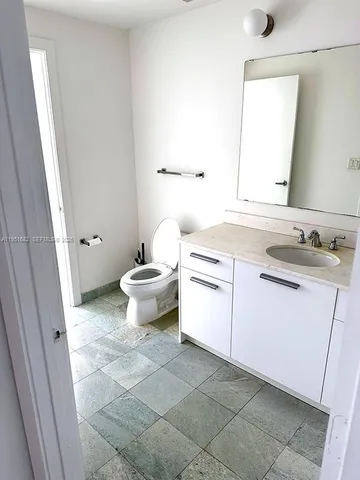 a bathroom with a sink toilet and mirror