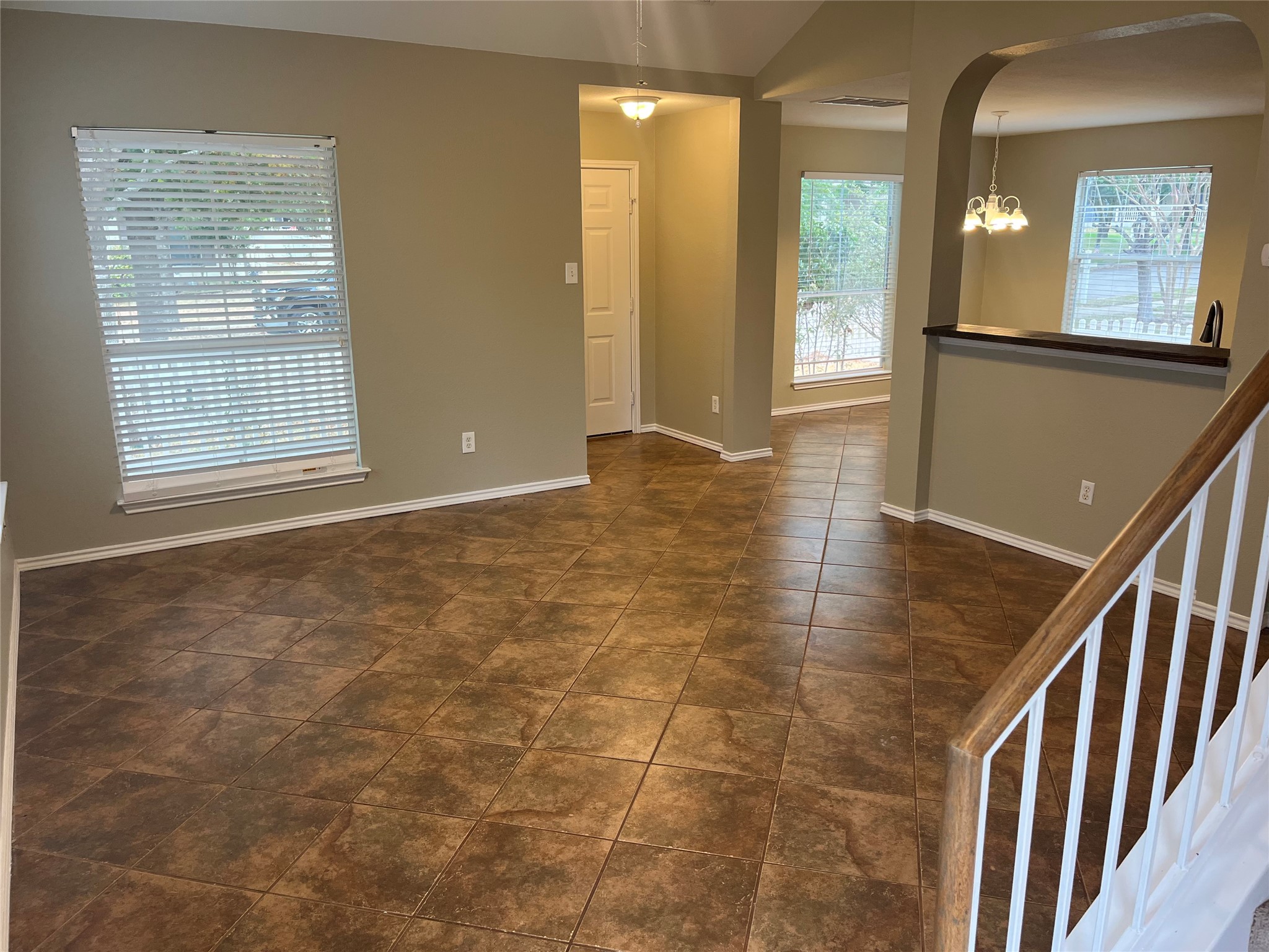 694 Hogan Kyle, TX 78640 - Photo 17 of 20 Spare room with a chandelier, arched walkways, and dark tile patterned floors