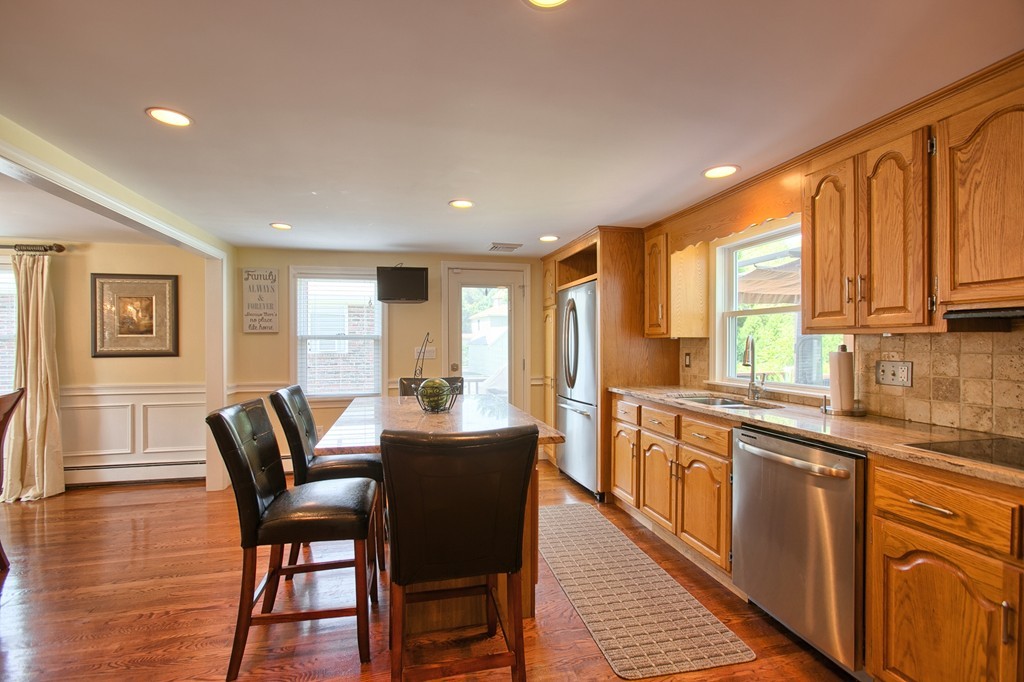29 Spring Street Wakefield, MA 01880 - Photo 11 of 30 a large kitchen with stainless steel appliances granite countertop a stove a sink a dining table and chairs