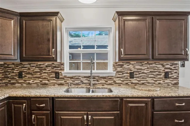 a kitchen with granite countertop a sink and a stove