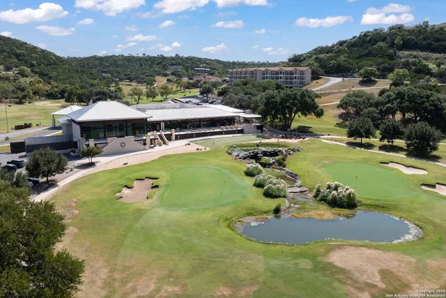 an aerial view of a house with swimming pool and mountains