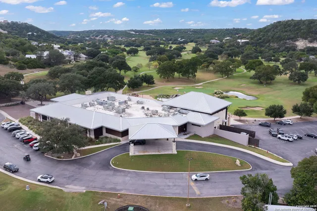 an aerial view of residential houses with outdoor space and trees