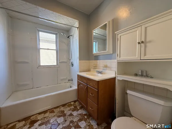 a bathroom with a granite countertop sink toilet and bathtub