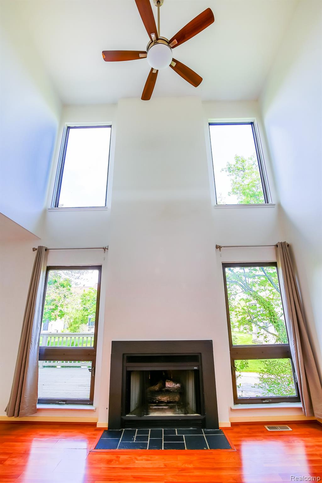 716 Eton Court Rochester, MI 48307 - Photo 5 of 41 Great room features 22' vaulted high ceiling w/ ceiling fan and a gas fireplace
