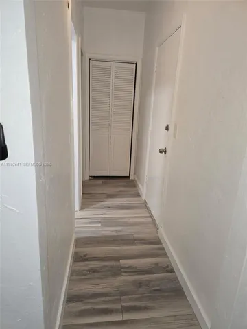a view of a hallway with wooden floor and entryway