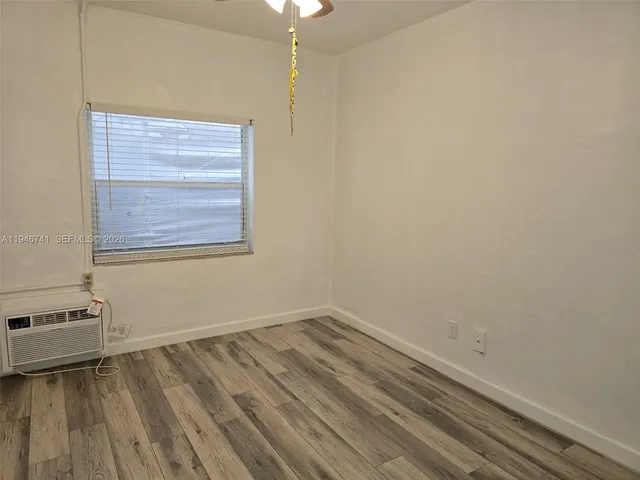 a view of a room with wooden floor and a window