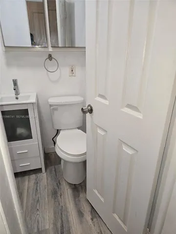a white toilet sitting next to a white cabinet