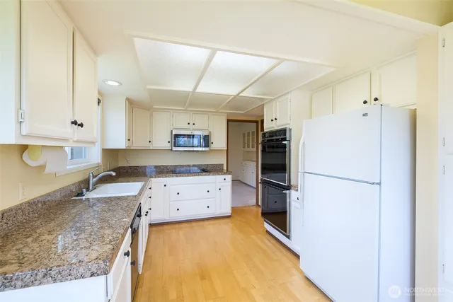 a kitchen with stainless steel appliances granite countertop a refrigerator and a sink