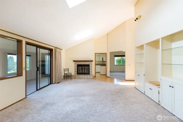 an empty room with windows and fireplace