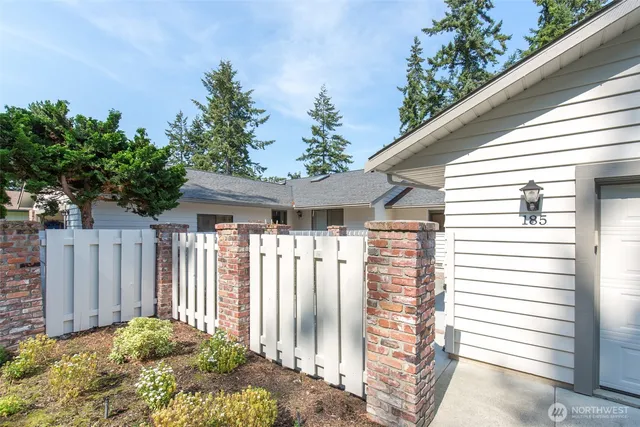 a view of a house with a small yard and wooden fence