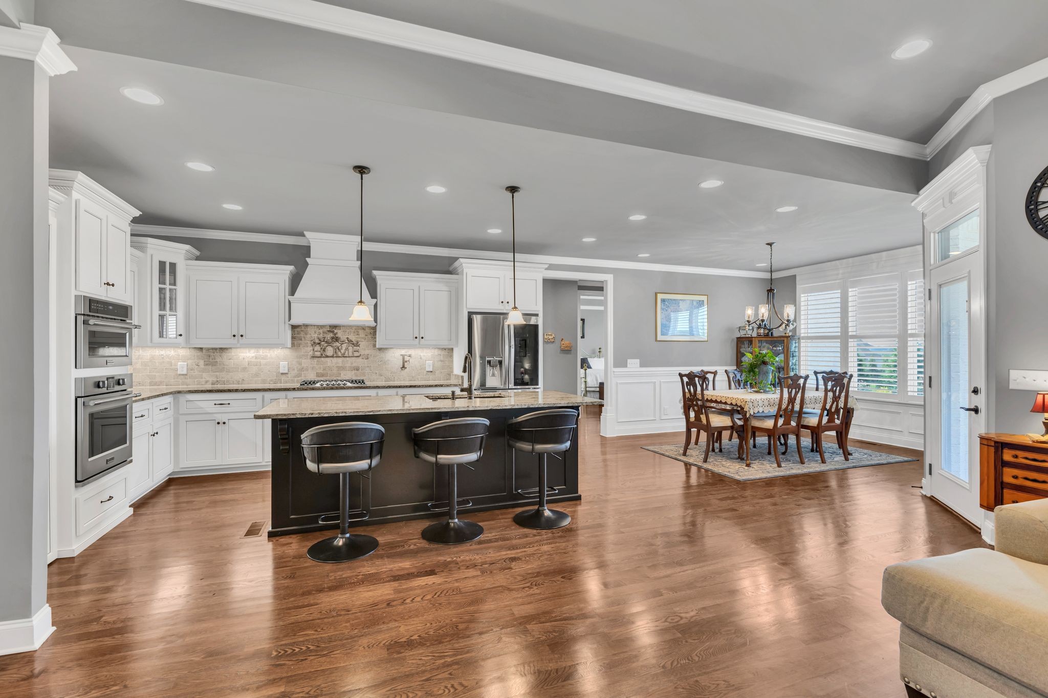 1007 Abbey Rd Way Spring Hill, TN 37174 - Photo 12 of 54 a kitchen with stainless steel appliances granite countertop a stove a refrigerator a kitchen island a dining table and chairs with wooden floor