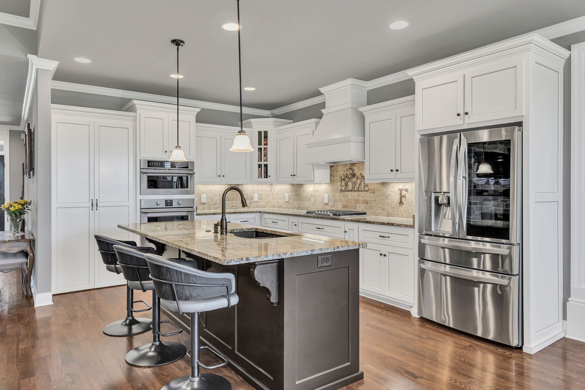 1007 Abbey Rd Way Spring Hill, TN 37174 - Photo 17 of 54 a kitchen with stainless steel appliances kitchen island a table chairs sink and cabinets