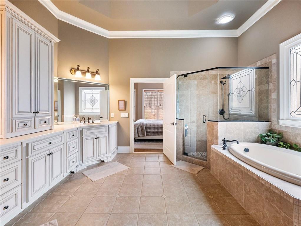 6147 Golf View Court Jefferson, GA 30549 - Photo 26 of 73 a spacious bathroom with a double vanity sink a mirror a bathtub and a window