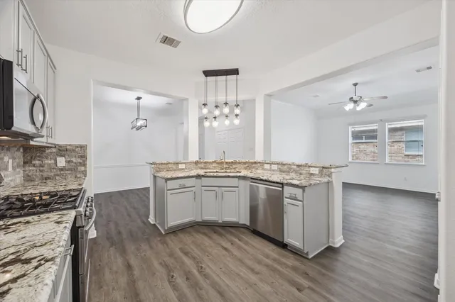 a kitchen with stainless steel appliances granite countertop a stove and cabinets