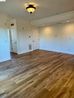 an empty room with wooden floor and natural light