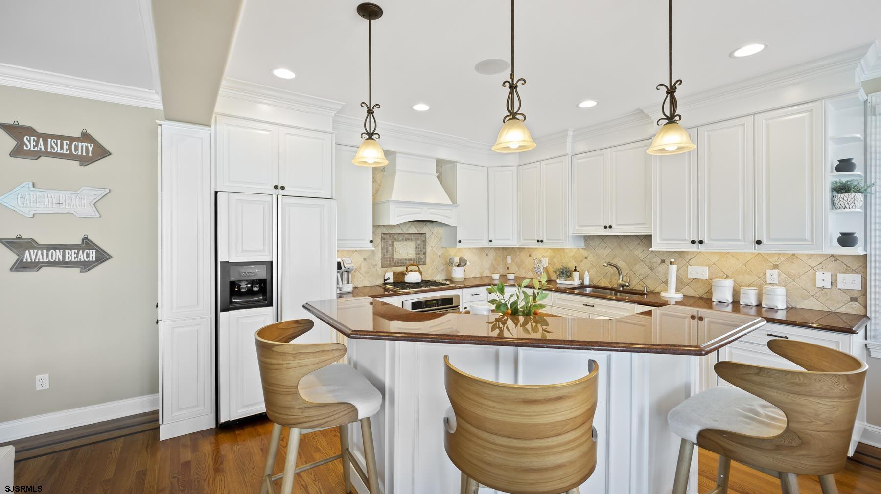 23 Walnut Road Ocean City, NJ 08226 - Photo 20 of 47 a room with stainless steel appliances kitchen island granite countertop a stove a sink a dining table and chairs with wooden floor