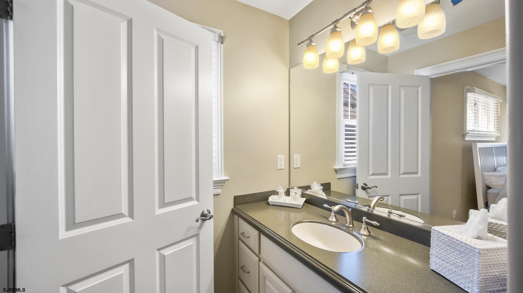23 Walnut Road Ocean City, NJ 08226 - Photo 32 of 47 a bathroom with a granite countertop sink and a mirror