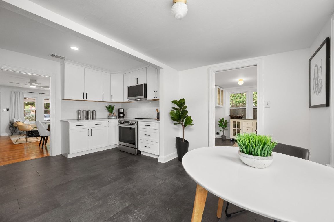 1412 Palo Duro Road Austin, TX 78757 - Photo 13 of 32 a kitchen with white cabinets and stainless steel appliances