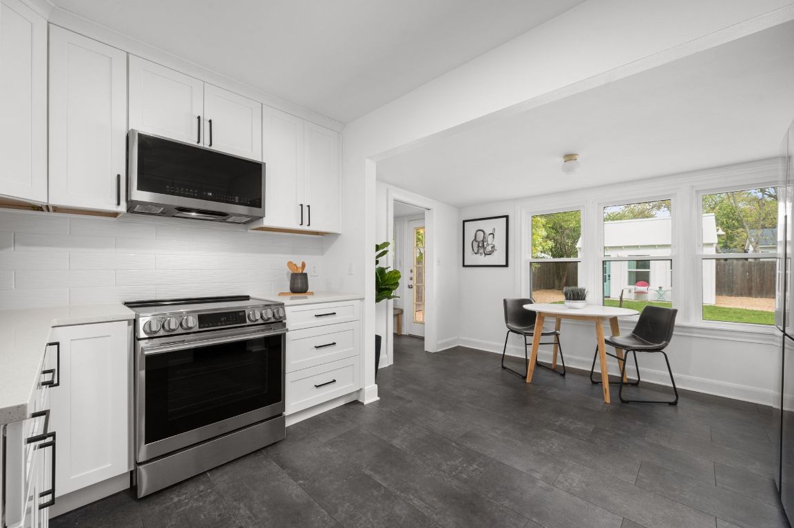 1412 Palo Duro Road Austin, TX 78757 - Photo 8 of 32 a kitchen with stainless steel appliances a stove a sink and a microwave